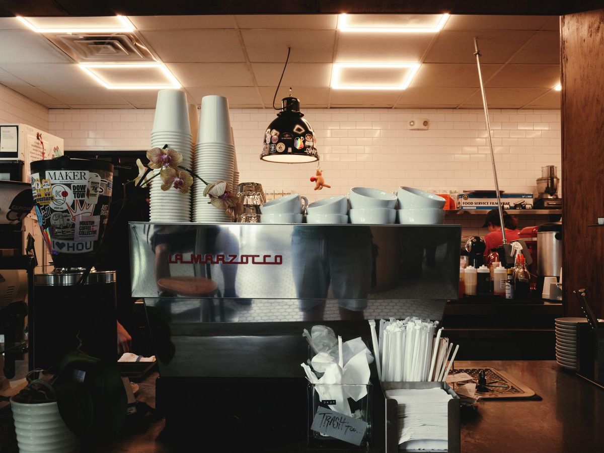 Inside a charming Houston coffee shop featuring a professional espresso machine and warm lighting.